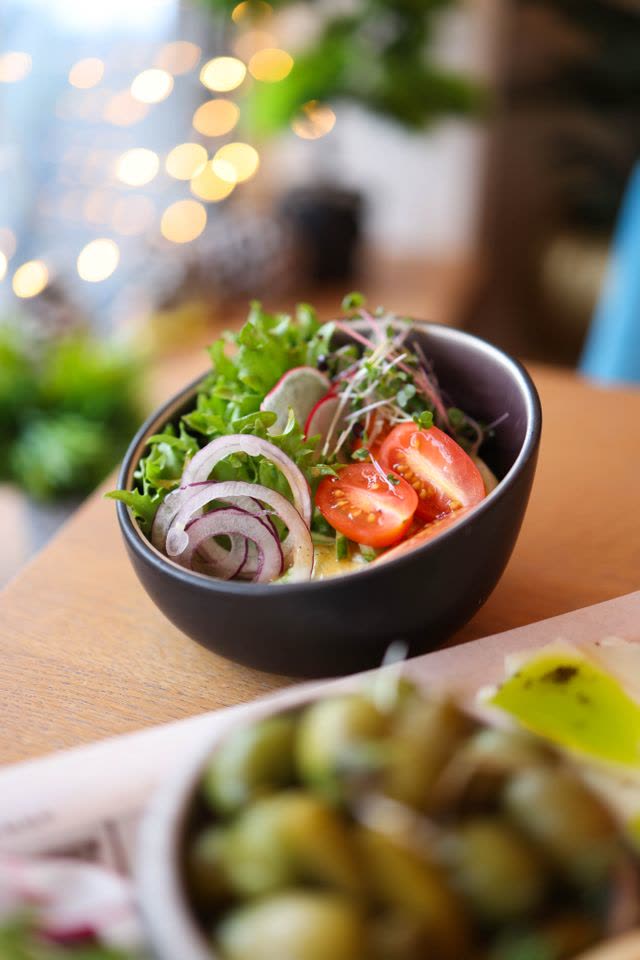A bowl of fresh salad with tomato and onion