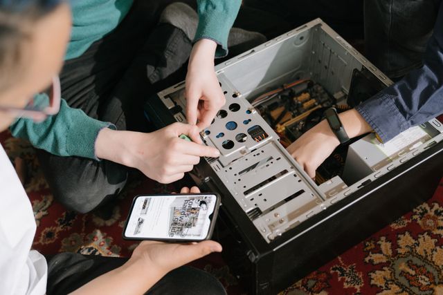 People fitting components inside an open desktop computer case