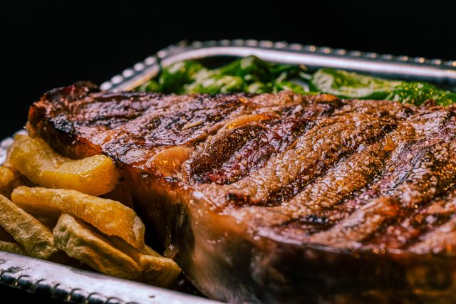 Grilled steak served with golden potatoes and green peppers