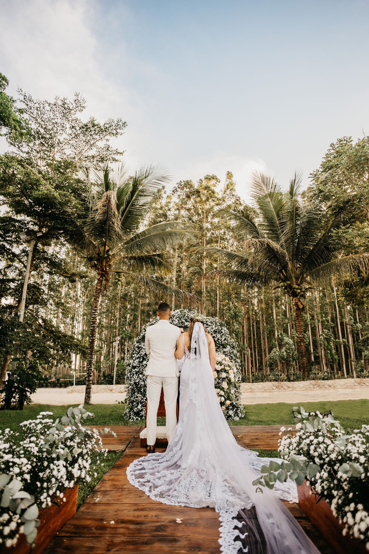 Outdoor wedding ceremony surrounded by trees and flowers