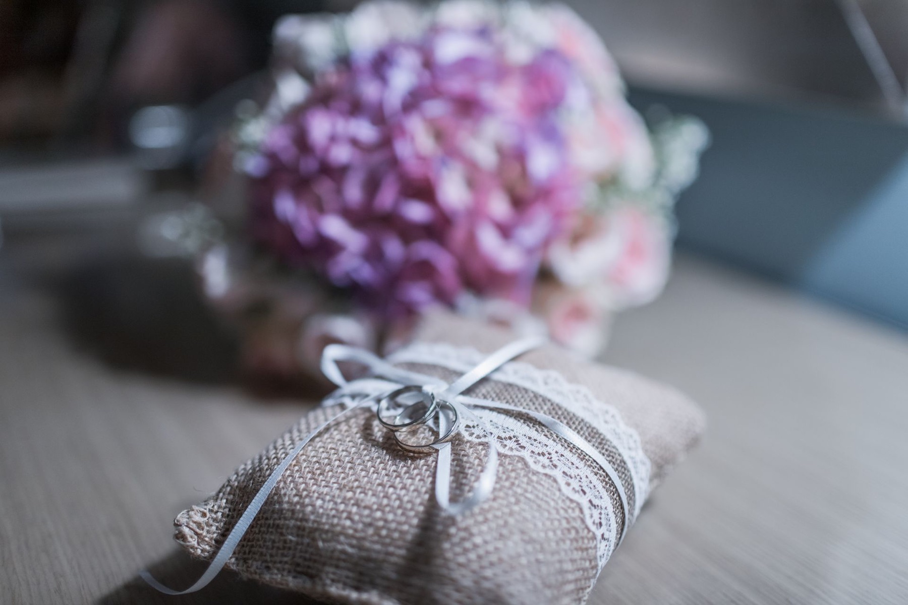 Wedding rings resting on a ribboned cushion