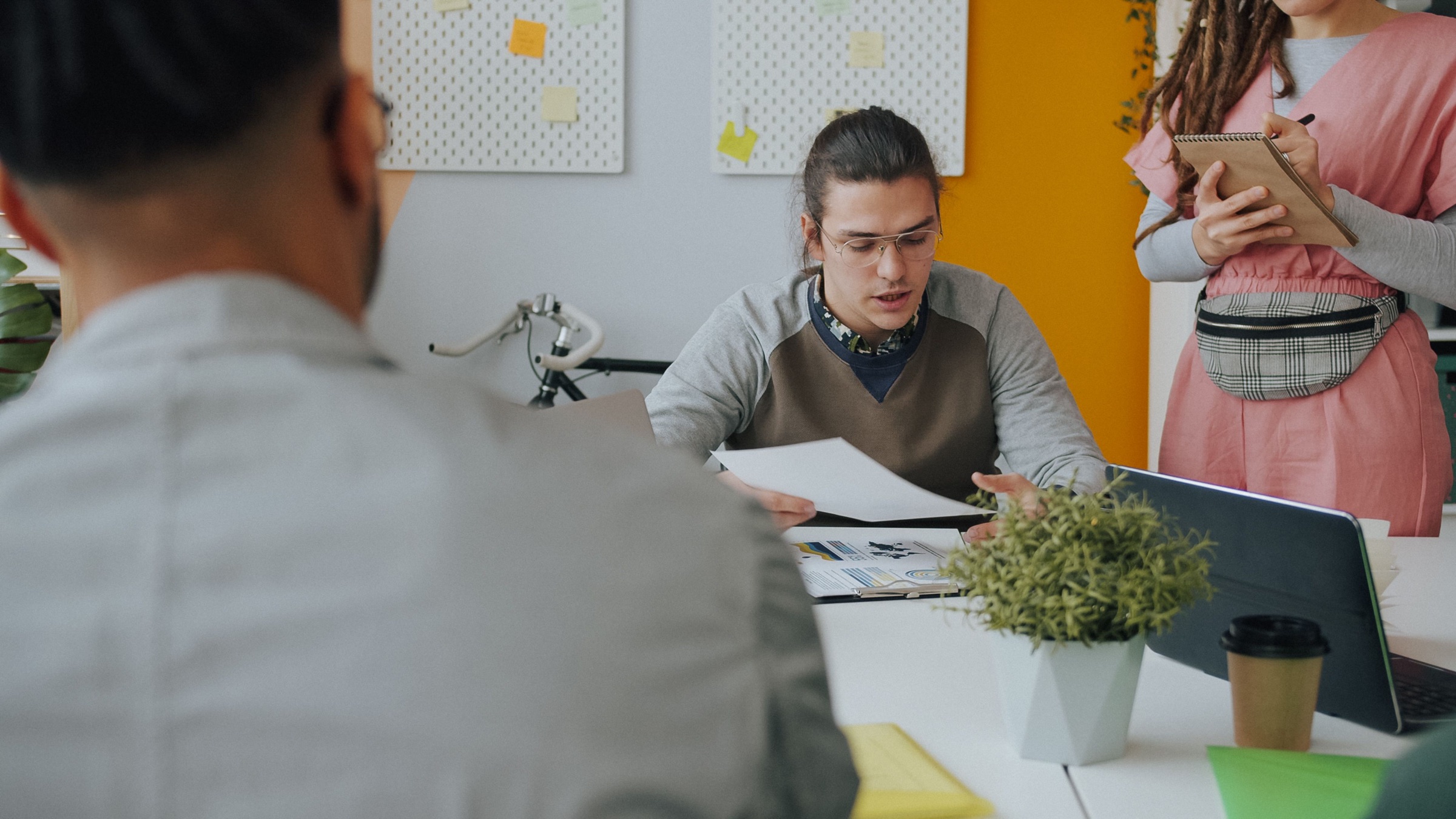 A small team discussing plans around a shared workspace