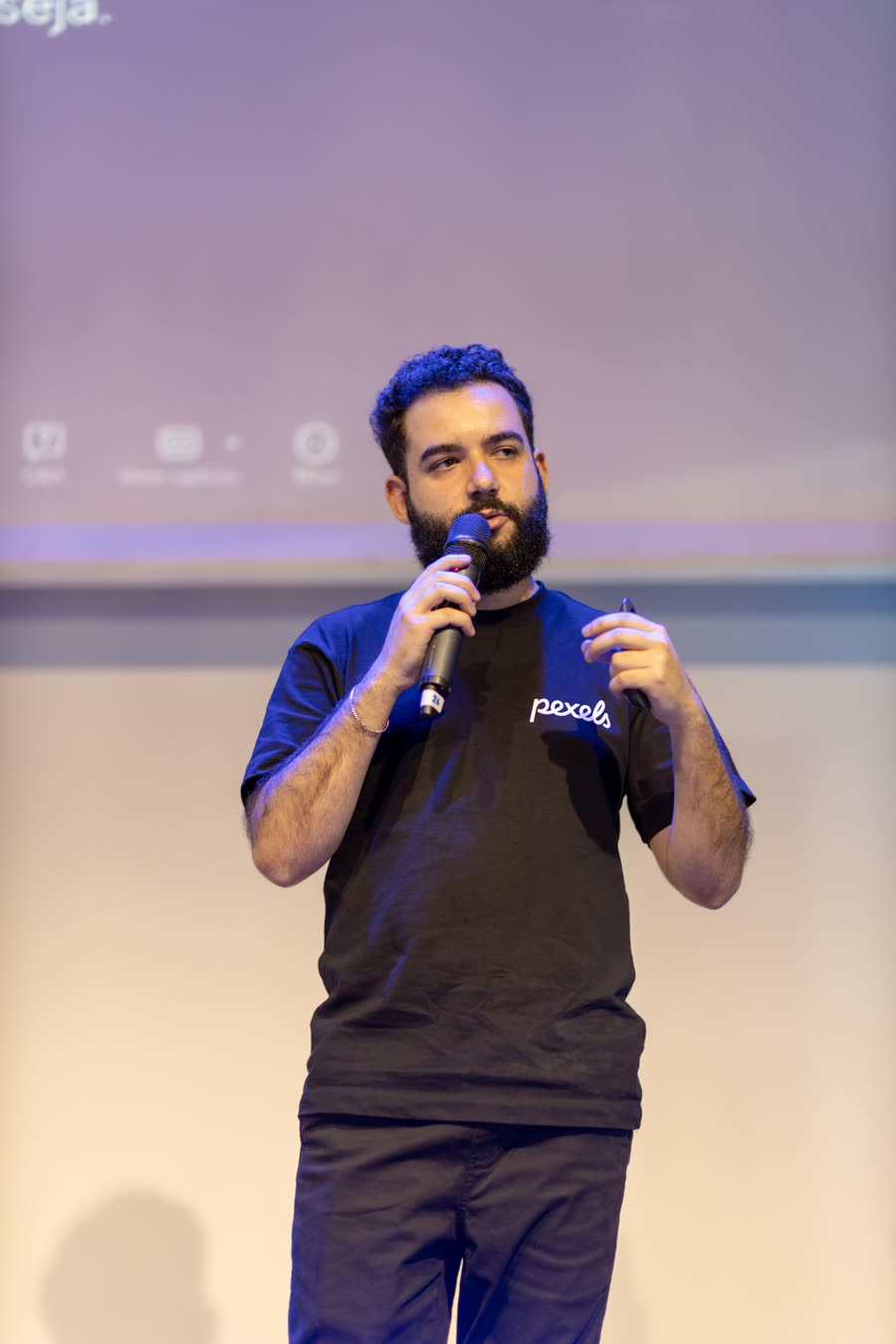 A speaker with a microphone on a lit stage