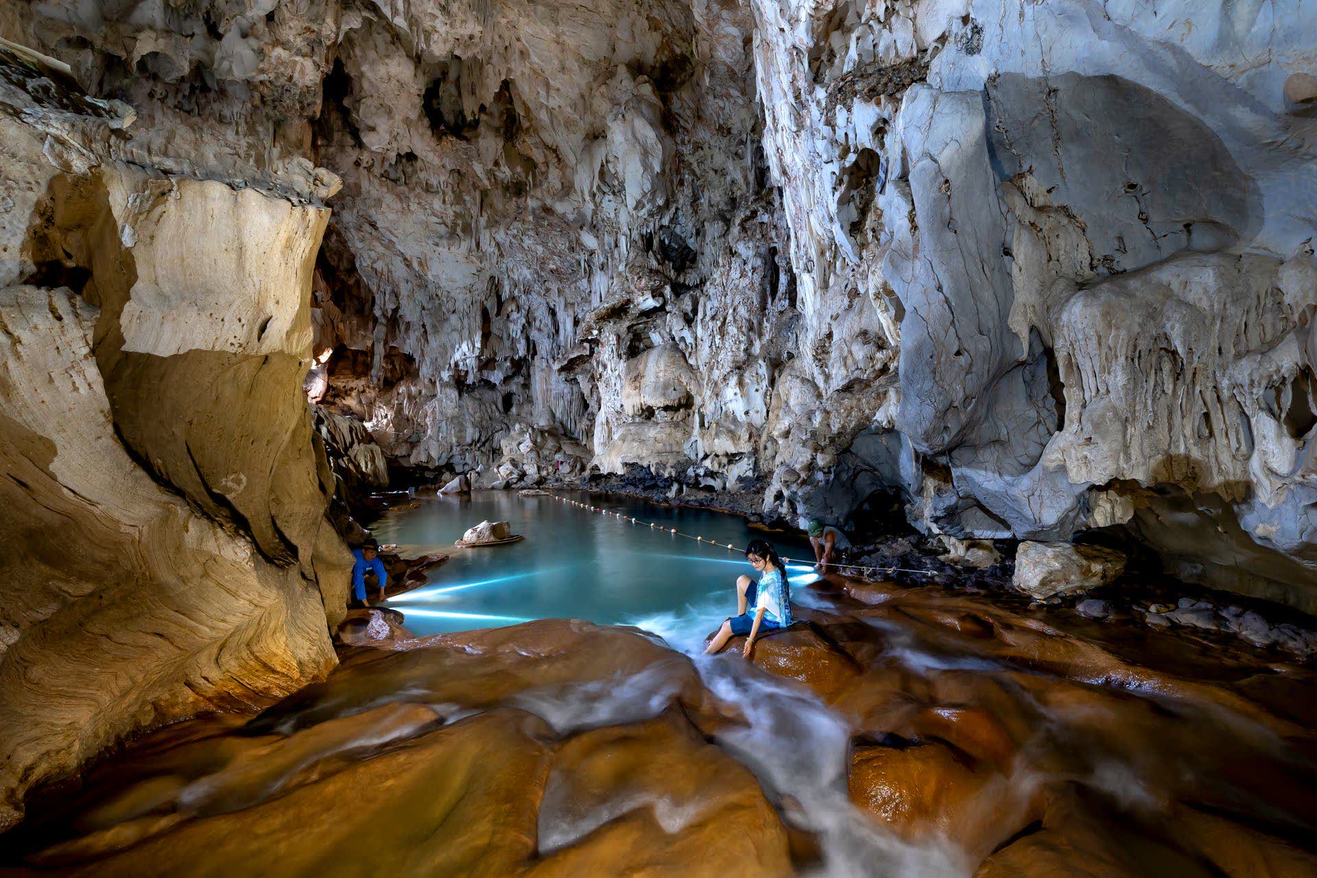 A river flowing between the rock walls of a cave lit from within