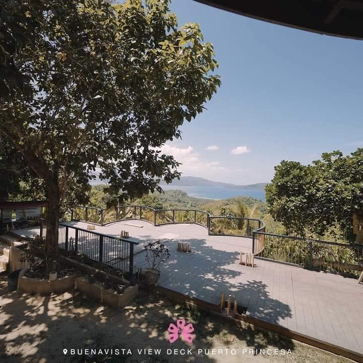 A shaded viewing deck overlooking a bay and distant hills