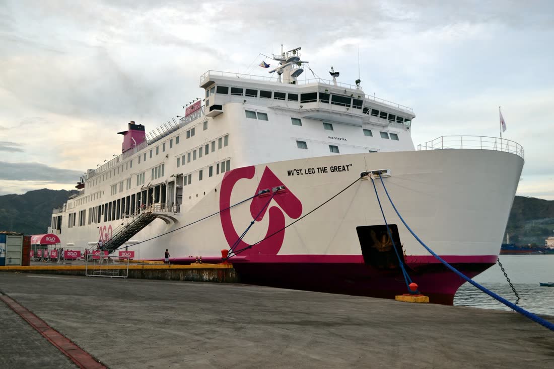 A large white passenger ferry docked at the pier