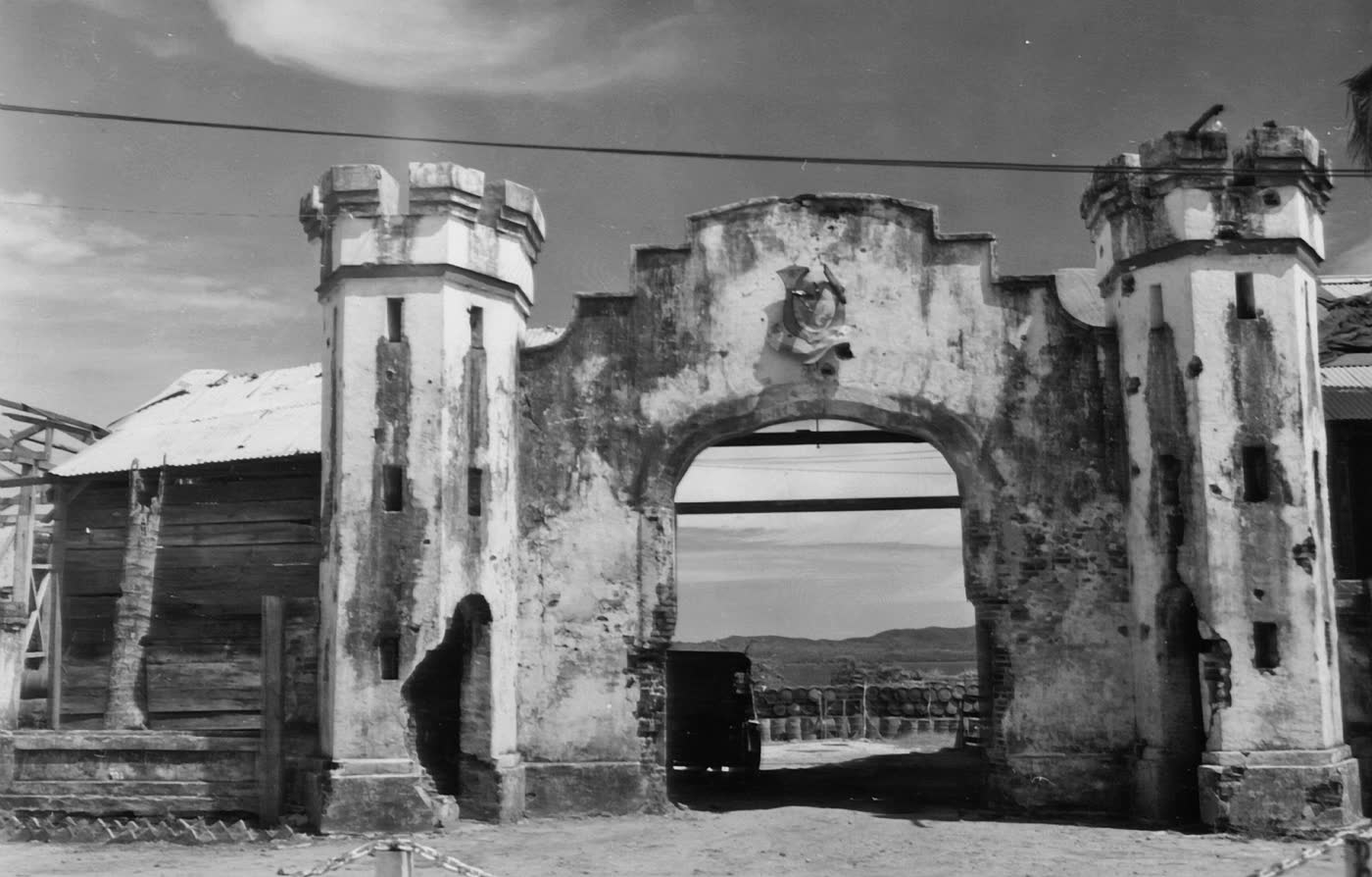 An archival black and white photograph of the stone gate of Plaza Cuartel