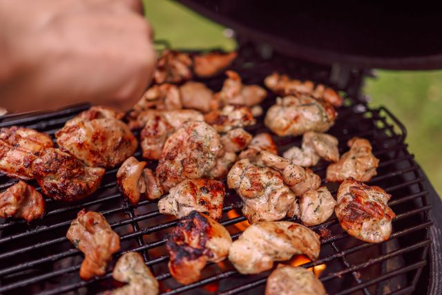 Marinated chicken charring on a charcoal grill