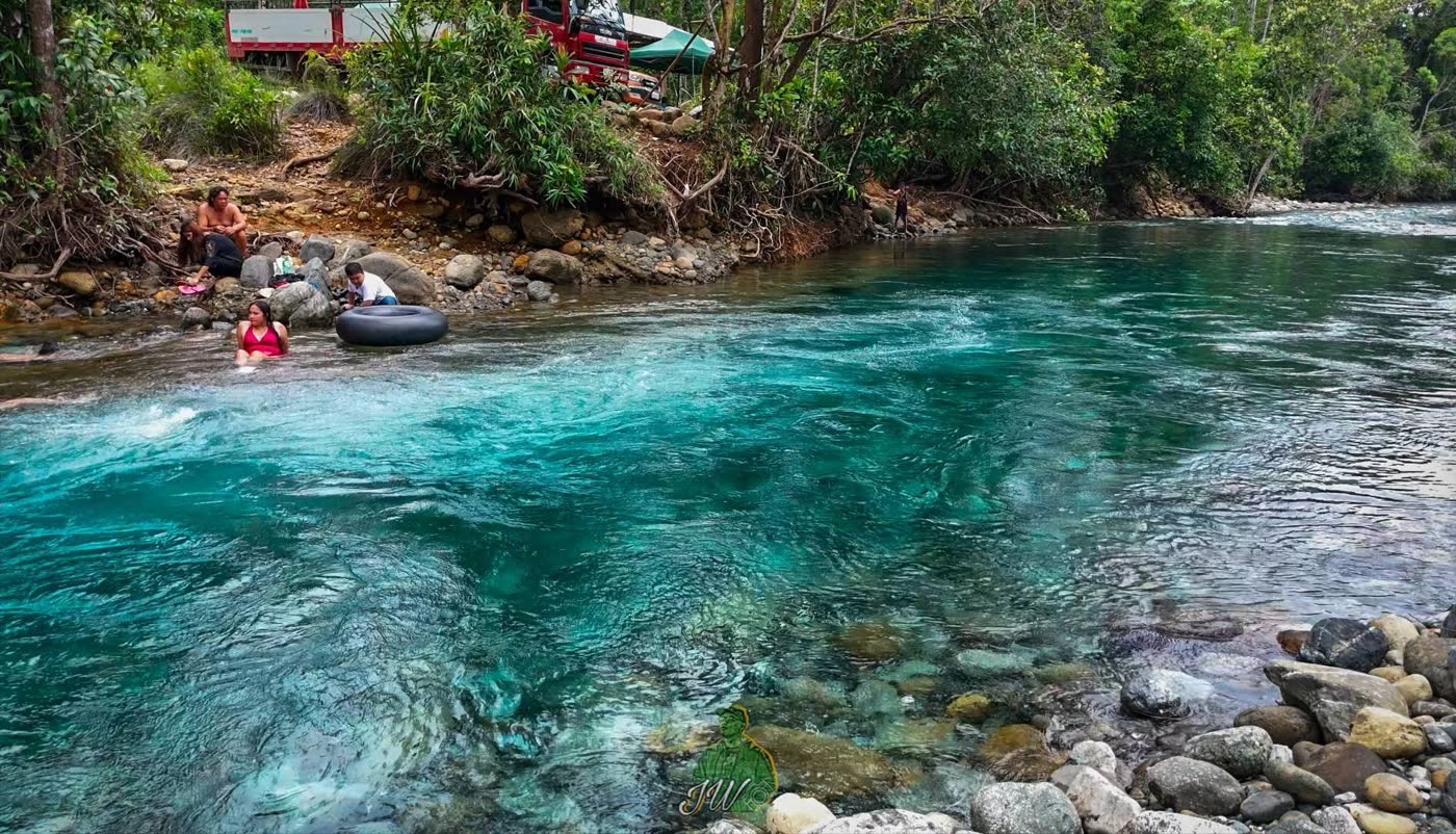 People floating on inner tubes in a fast, clear turquoise river