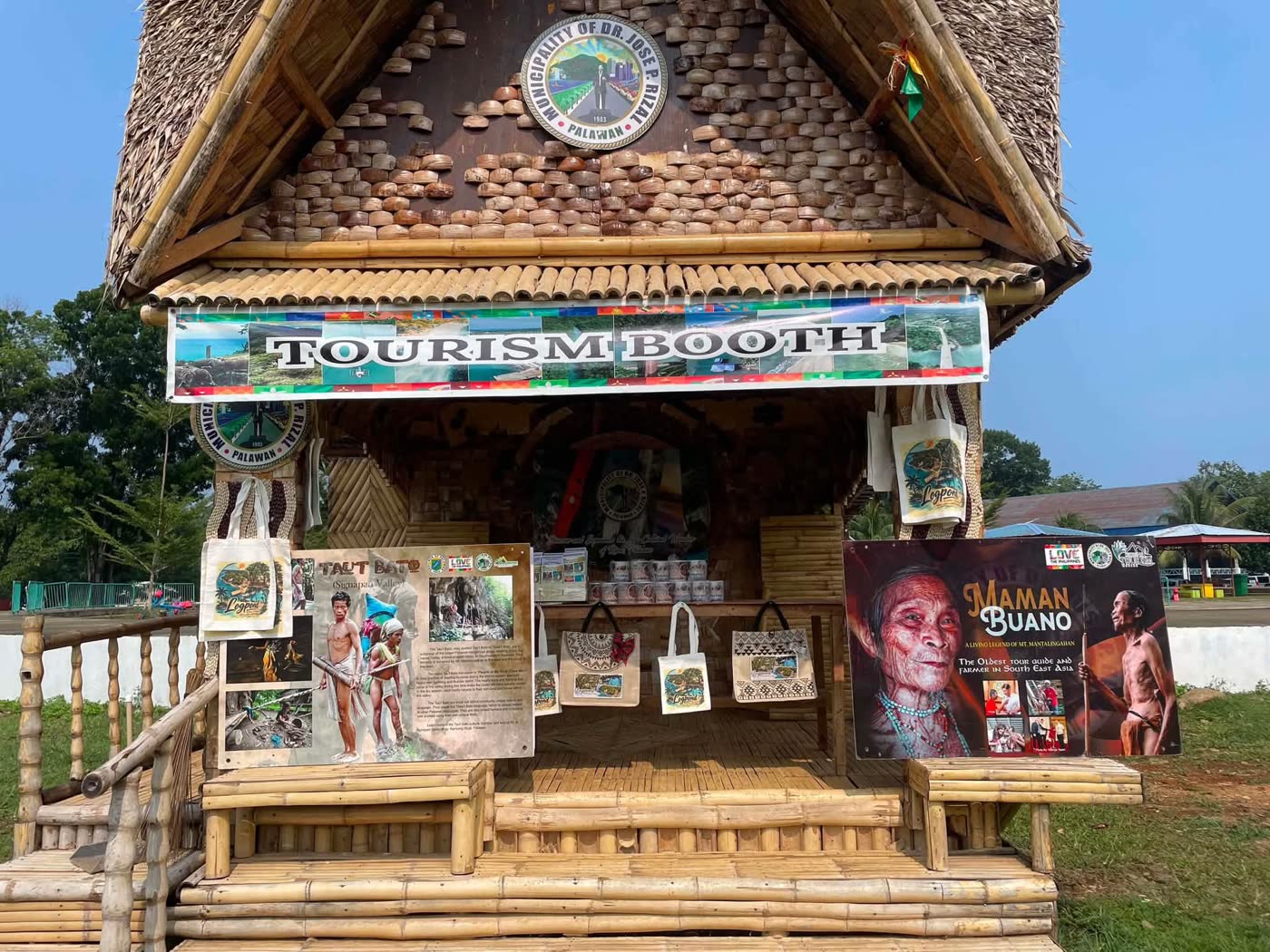 A bamboo tourism booth hung with portraits of Tau't Bato elders and woven bags