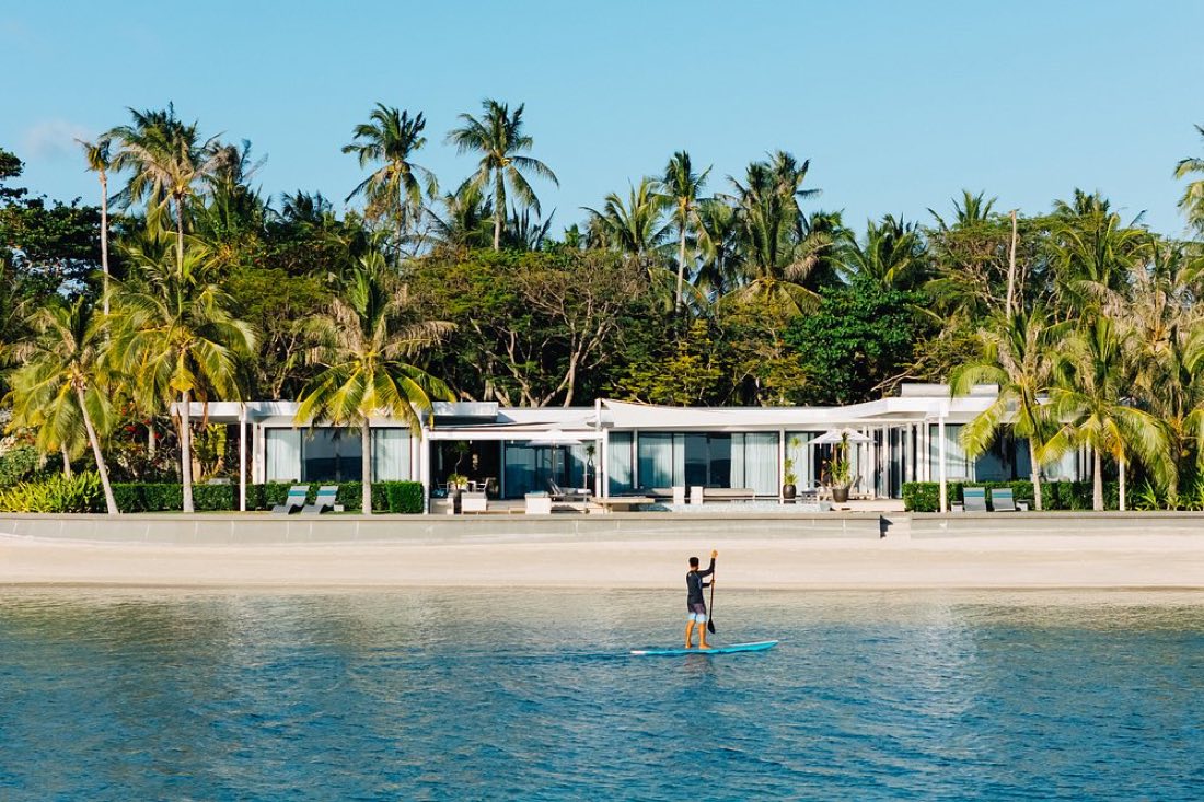 A beachfront villa behind palms