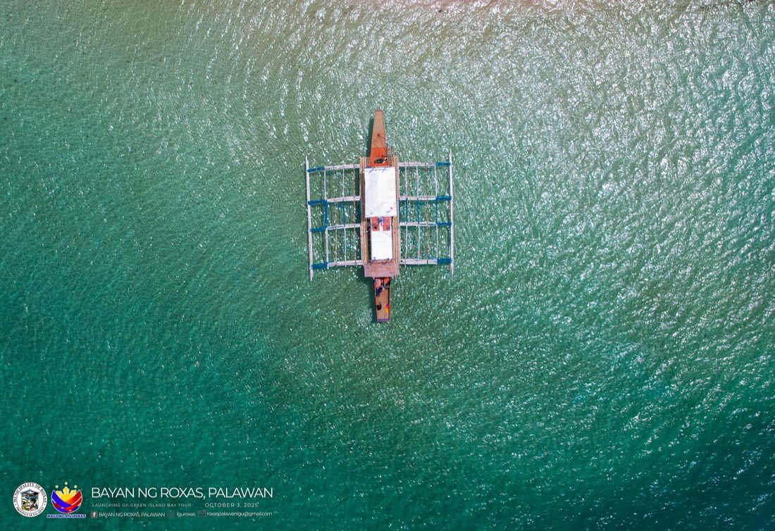 Top-down view of an outrigger bangka on clear water