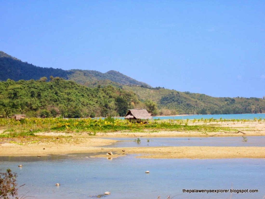 A river mouth meeting the sea with hills behind