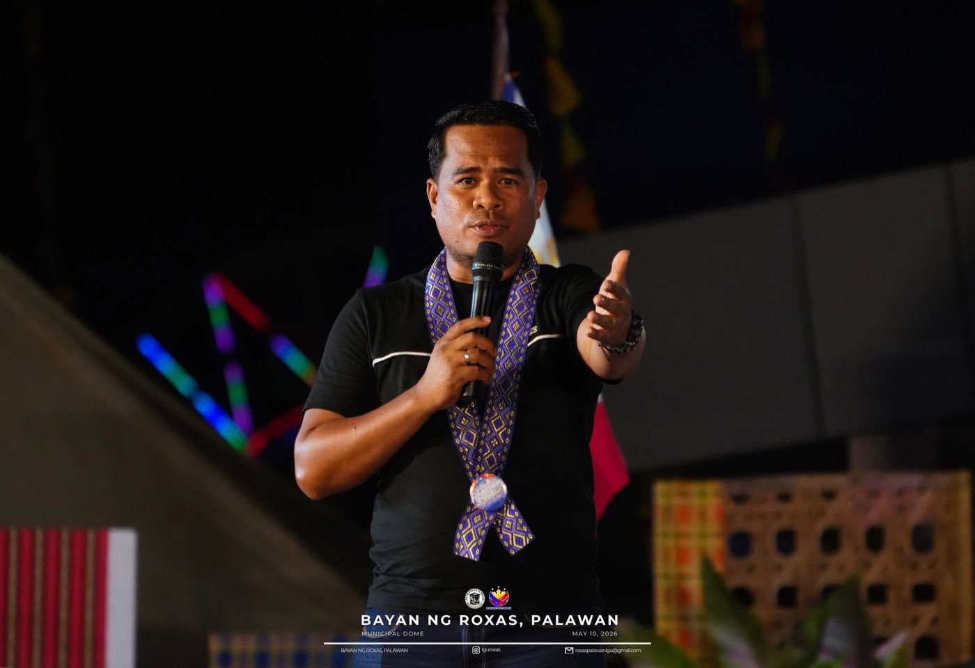 Mayor Pedy B. Sabando speaking into a microphone on stage at night