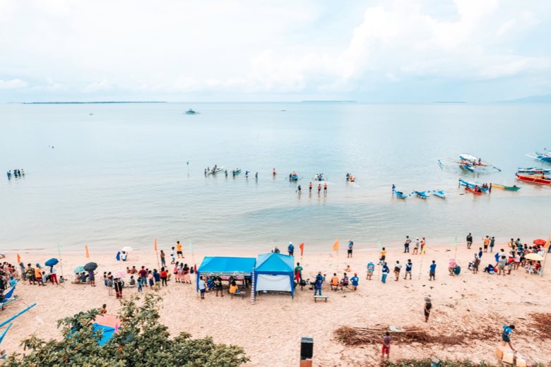 Crowds on the beach watching boats come in