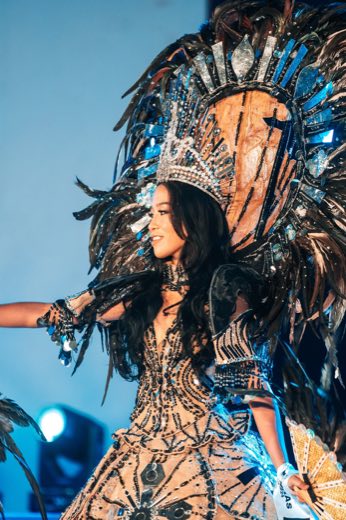 A pageant candidate in a feathered headdress