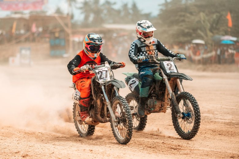 Two motocross riders racing on sand