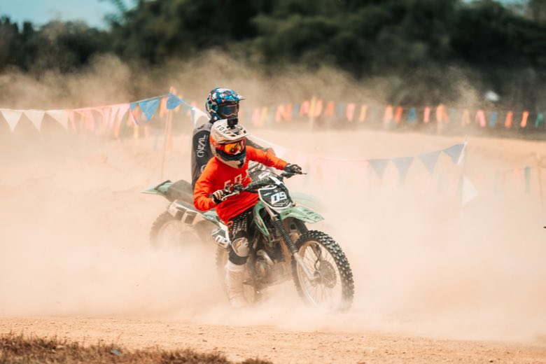 A motocross rider turning on a sand track