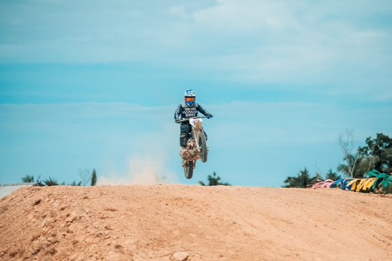 A motocross rider in mid-air over the sand
