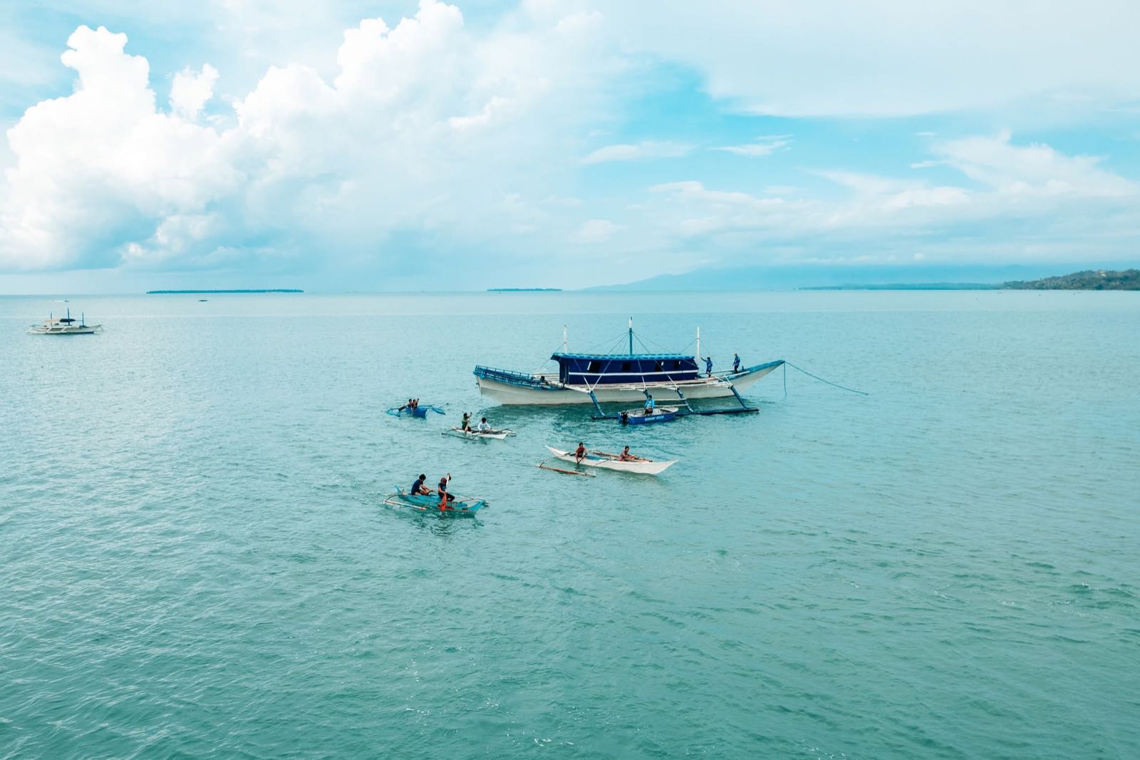Bangkas and small boats gathered on calm turquoise water