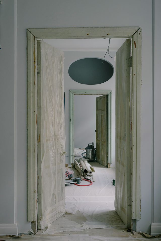 A doorway mid-renovation with fresh frame and plastered walls
